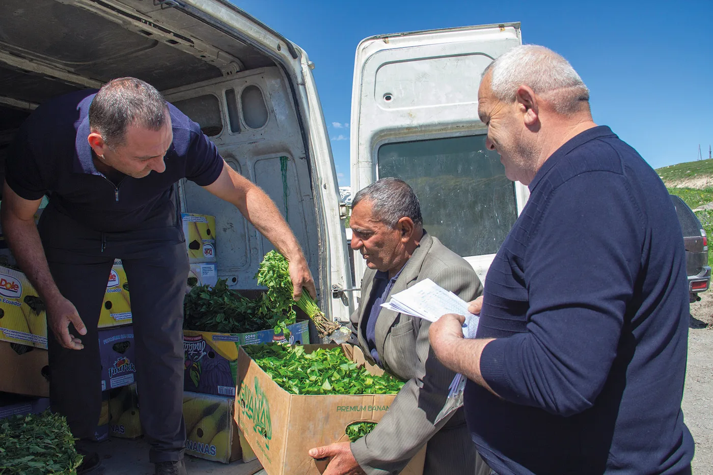 Deux hommes d’HimnaTavush sortent des cartons de semis d’une camionnette avec le chef du village de Mutsk